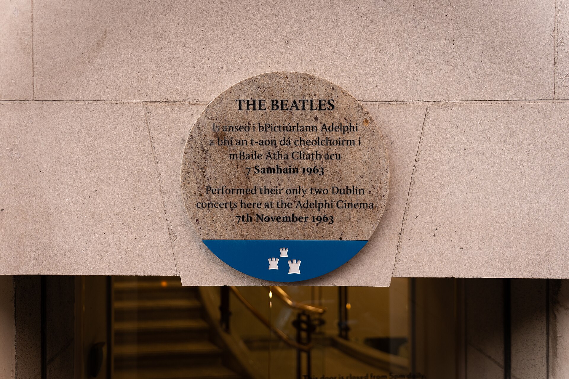 Round Dublin City Council plaque in Irish and English marking the Beatles' only two Dublin concerts at the Adelphi Cinema, 7 November 1963