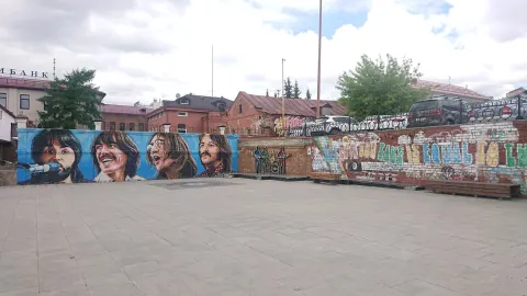 Cast-iron silhouettes of the four Beatles on a brick wall at the Beatles monument in Yekaterinburg