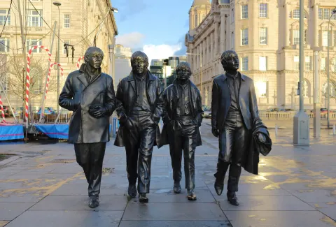 Bronze Beatles Statue by Andy Edwards at Pier Head, Liverpool, showing the four band members walking