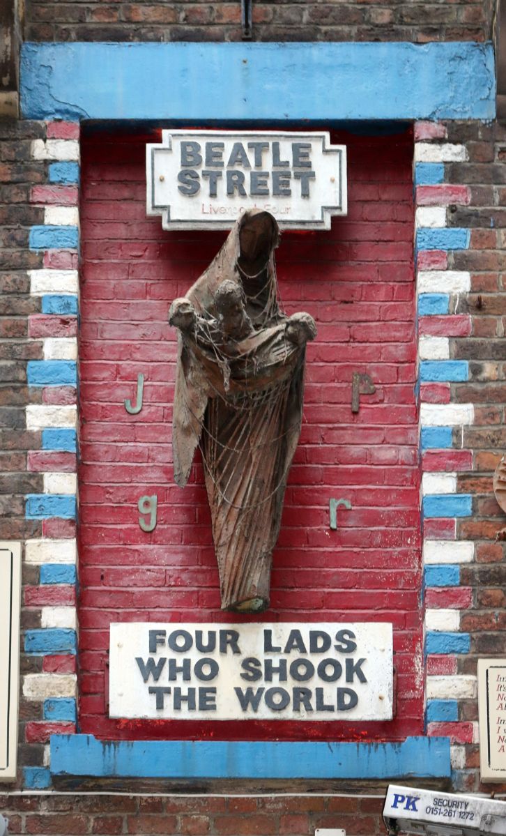 Arthur Dooley's Four Lads Who Shook the World sculpture, a Madonna figure holding infant Beatles, on the wall of Eric's on Mathew Street, Liverpool