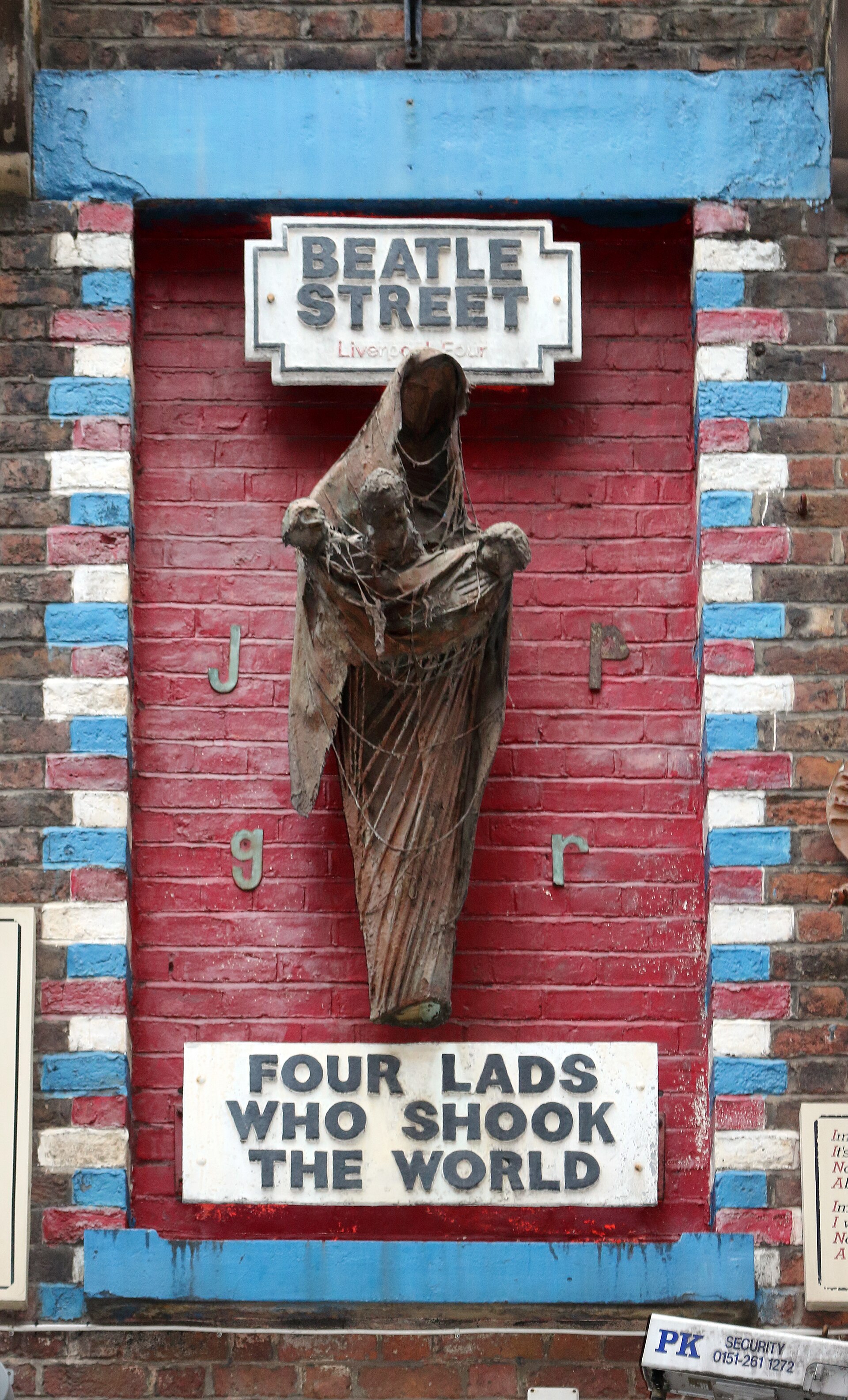 Arthur Dooley's Four Lads Who Shook the World sculpture, a Madonna figure holding infant Beatles, on the wall of Eric's on Mathew Street, Liverpool