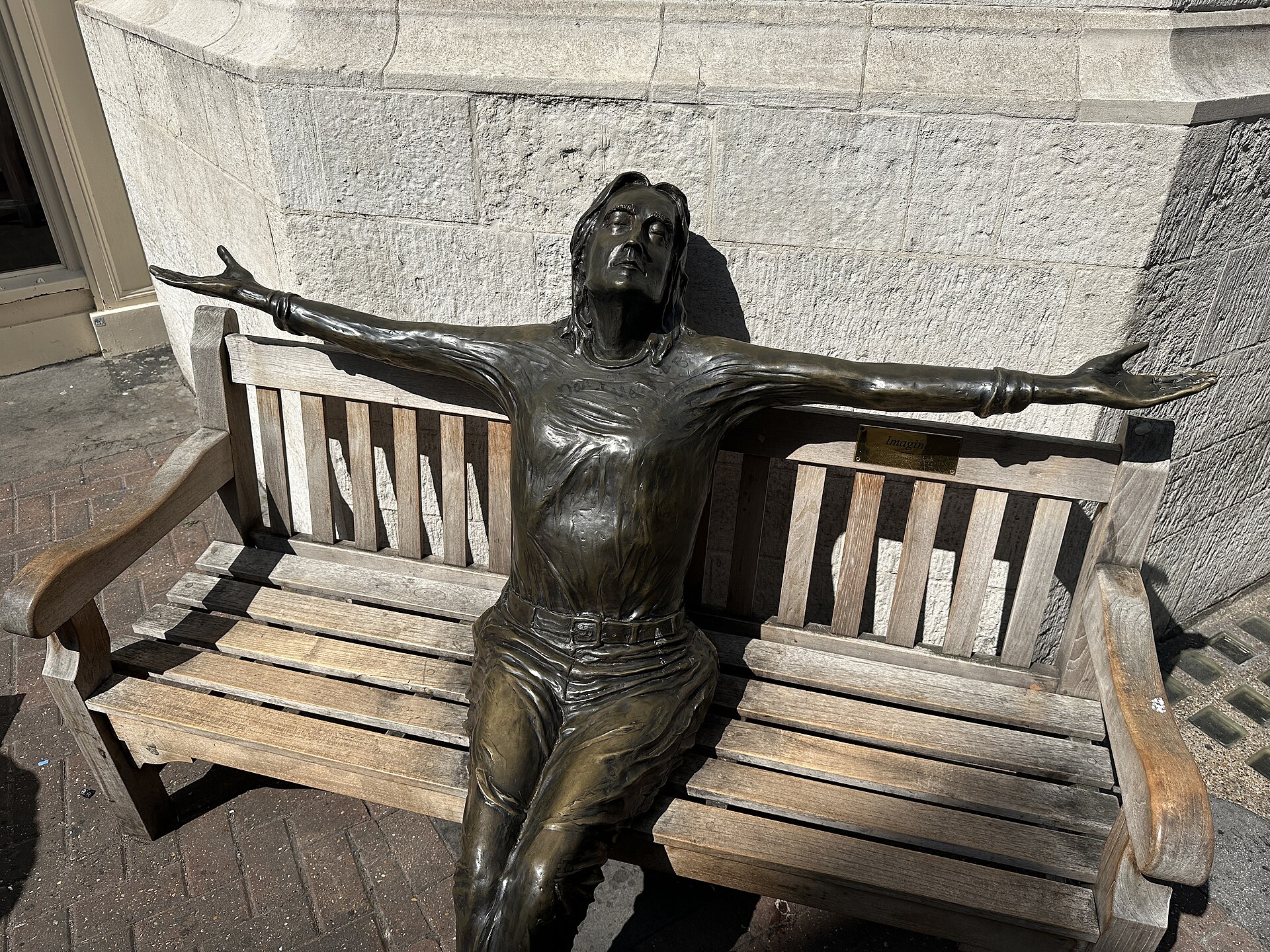 Lawrence Holofcener's bronze Imagine statue of John Lennon on a bench on Carnaby Street, London