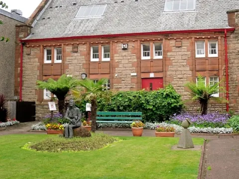 Bronze statue of Linda McCartney holding a lamb in the Linda McCartney Memorial Garden, Campbeltown