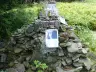 Stone cairn of the John Lennon memorial below the summit of Smrk in the Beskydy mountains, with photos of Lennon and candles on top