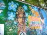 Painted portrait of John Lennon among blue flowers and visitors' writing on the Lennon Wall in Prague, October 2022