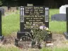 Black headstone of Stuart Sutcliffe's family grave in the churchyard of St Michael's Church, Huyton, 2021